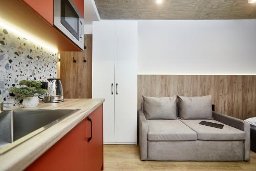 a kitchen with a couch in the corner of a room at City Rooms Arcadia Self Check-In in Odesa