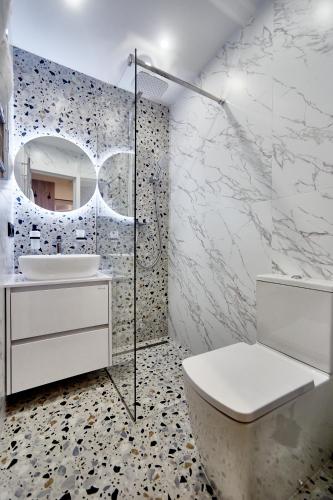 a bathroom with a toilet and a sink and a mirror at City Rooms Arcadia Self Check-In in Odesa