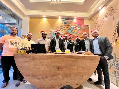 a group of men standing around a table with a cake at Sugar Stars Inn in Varanasi