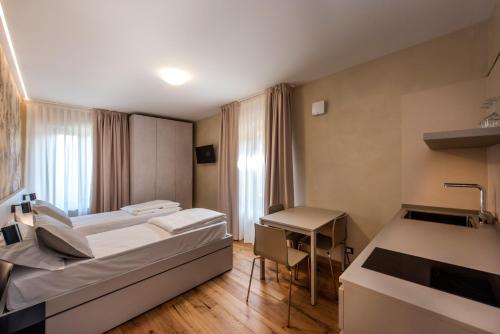 a hotel room with two beds and a desk at La Blave Rooms in Mortegliano