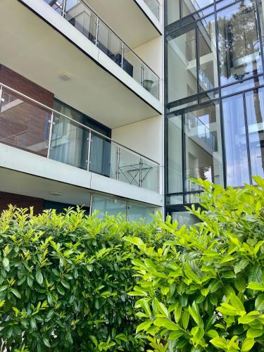 an office building with green bushes in front of it at Azúr Port Siófok With Free Wellness in Siófok