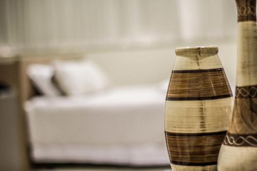 two vases sitting on a table with a couch at Blu Apart Hotel in Mogi-Guaçu