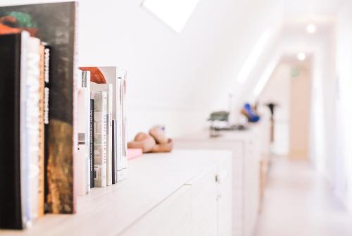 a row of books on a white shelf at Logement Overzee in Nes