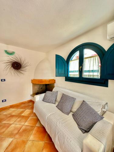a living room with a couch and a window at Jennas-Libeccio Apartment in Àrbatax