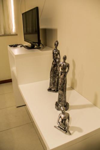 two bronze statues sitting on a white table at Blu Apart Hotel in Mogi-Guaçu