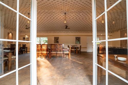 une salle à manger avec des tables et des chaises dans un bâtiment dans l'établissement Tiger Machan, à Sawai Madhopur