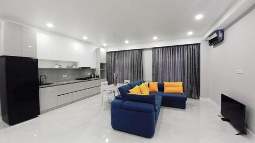 a living room with a blue couch and orange pillows at D-S Apartament in Kutaisi in Kutaisi