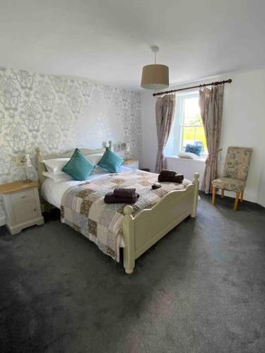 a bedroom with a bed with blue pillows and a window at Reeth, Yorkshire, walking & cycling routes in Reeth