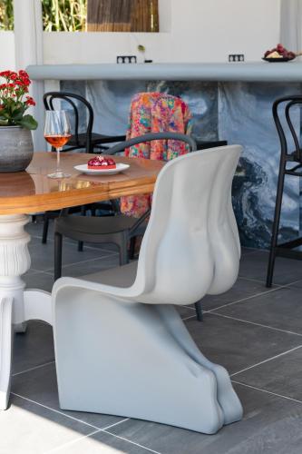 a white chair sitting next to a wooden table at Sea Lilies Suites in Plaka
