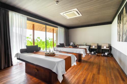 a hospital room with four beds and a window at Madifushi Private Island in Meemu Atoll