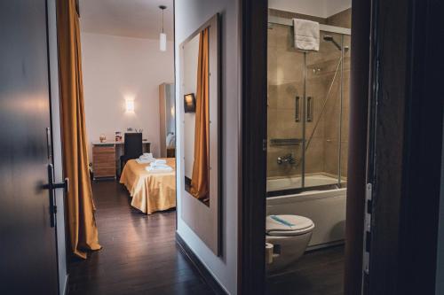 łazienka z toaletą, prysznicem i stołem w obiekcie Hotel Majesty Alberobello w Alberobello