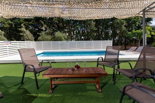 um pátio com uma mesa e cadeiras e uma piscina em Villa Astravi em Ialyssos