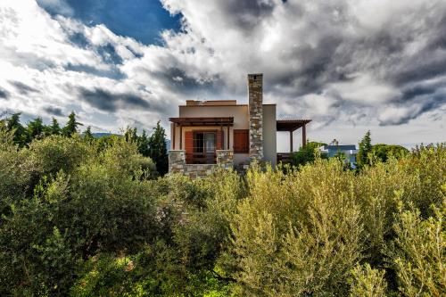 een klein huis bovenop een heuvel met struiken bij Villa Astravi in Ialyssos