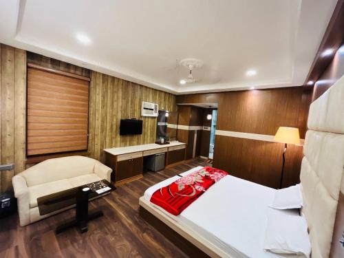 a bedroom with a bed and a chair in a room at Hotel Majestic in Kolkata