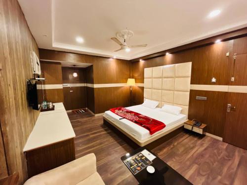 a bedroom with a bed and a table in it at Hotel Majestic in Kolkata