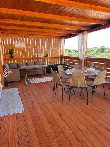 a patio with a table and chairs on a wooden deck at Green Turtle Holiday - Lovely, brand new holiday home near the sea in Drage