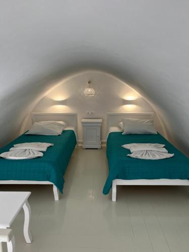 two beds in a white room with green sheets at Villa Pavlina in Karterados