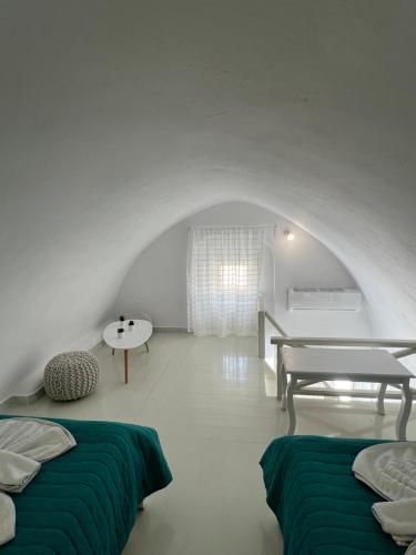 a white room with two beds and a table at Villa Pavlina in Karterados