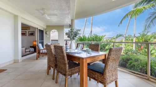 comedor con mesa y sillas en el balcón en Island Point Villa 2 Port Douglas, en Port Douglas