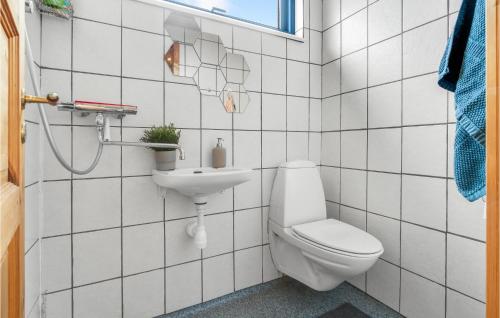 a white bathroom with a toilet and a sink at Nice Apartment In Allinge With Wifi in Allinge