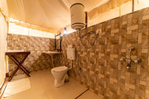 a bathroom with a toilet and a sink at Tiger Machan in Sawāi Mādhopur
