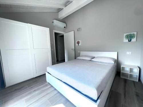 a white bedroom with a bed and a closet at VILLA CLAUDIA WITH PRIVATE POOL in Colico