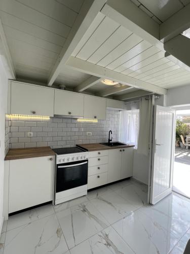 a kitchen with white cabinets and a stove at Villa Pavlina in Karterados