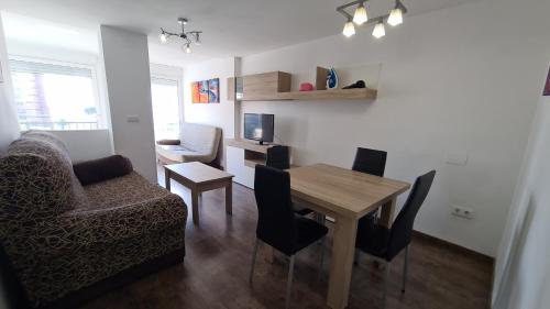 sala de estar con mesa, sillas y sofá en Apartamento Edificio Ilice -5, en Benidorm