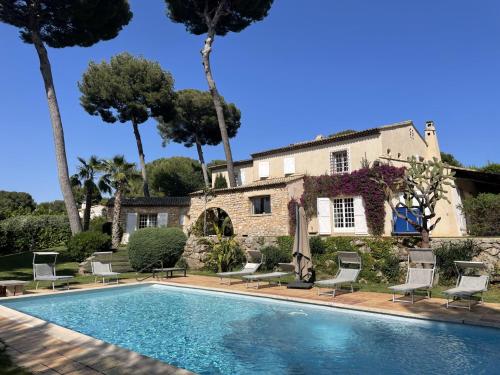 une piscine devant une maison avec des palmiers dans l'établissement Magnifique Villa de prestige Antibes/Juan-les-Pins, à Antibes