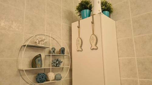 a bathroom with a white cabinet with vases and plants at STAY Kapparis Symphony in Paralimni