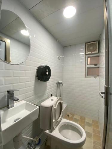 y baño con aseo, lavabo y espejo. en Hong Kong Hostel, en Hong Kong