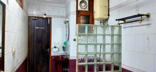a room with a door and a toilet and a clock at Trehan's Residence in New Delhi