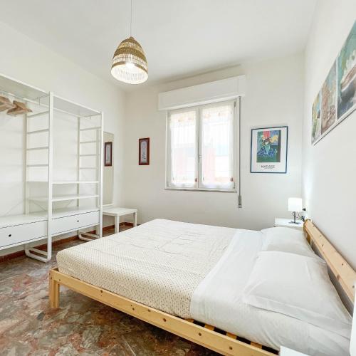 a white bedroom with a large bed and a window at Il Mare In Giardino in Scauri