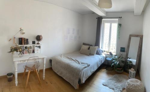 1 dormitorio con cama, escritorio y espejo en YOGAILO maison de charme, en Colombiers