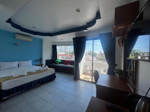 ein Hotelzimmer mit einem Bett und einem großen Fenster in der Unterkunft Heaven House in Patong Beach
