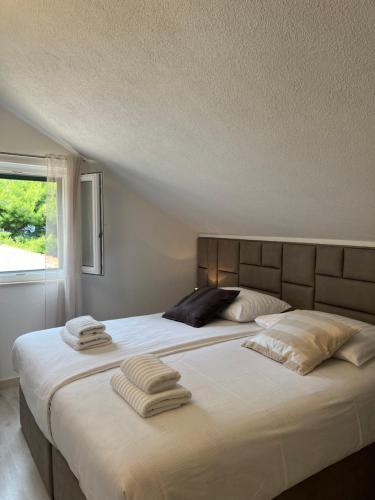 una camera da letto con un grande letto con asciugamani di Lučica, Luxury Rooms By the Sea a Pučišća