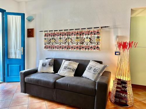 a living room with a leather couch and a vase at Jennas-Maestrale Apartment in Àrbatax