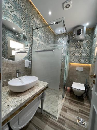 ein Bad mit einem Waschbecken, einer Dusche und einem WC in der Unterkunft BS Lodging 15 - Next to Dream Beach in Hurghada