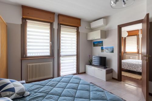 1 dormitorio con 1 cama, TV y ventanas en Casa vacanze- Debra, en Aosta