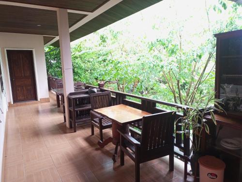 una sala da pranzo con tavoli e sedie su un portico di Phamarn View Guesthouse a Ban Nahin-Nai (2)