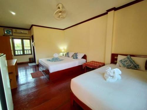 Phamarn View Guesthouse في Ban Nahin-Nai: غرفة بسريرين في غرفة بها