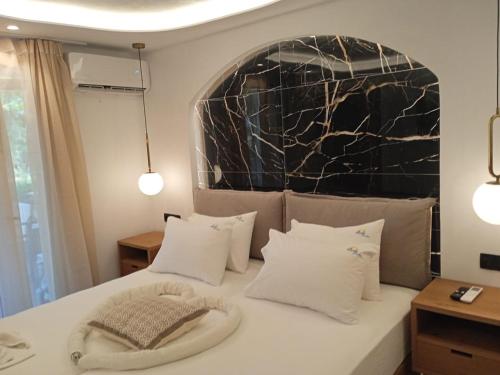 a bedroom with a white bed with white pillows at Acti Plaka Hotel in Plaka
