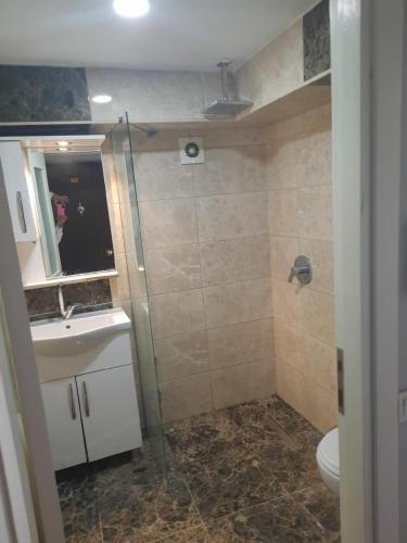 a bathroom with a shower and a sink and a toilet at Kuşadası Apart Dairelerimiz in Kuşadası