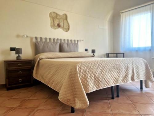 a bedroom with a bed with a blanket on it at Ca' dal Bertu - Cascina in Monferrato in Rosignano Monferrato
