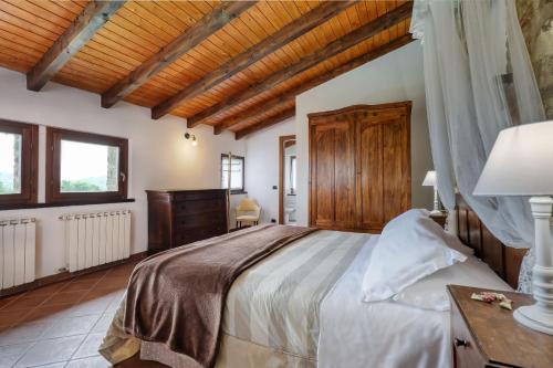 a bedroom with a large bed and a wooden ceiling at Ca' del Monte Resort in Serra del Monte