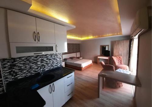 a room with a kitchen and a living room at Kuşadası Apart Dairelerimiz in Kuşadası