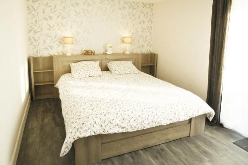 una camera con un letto con due cuscini sopra di l'Orée du Bois a Saint-Brice