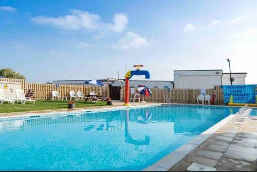 a swimming pool with a water slide in a yard at Whitstable, CW18, 2 bed park home, Alberta Holiday Park in Seasalter