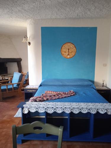 a bed with a blue wall with a clock on it at Casa Martine in Orosei