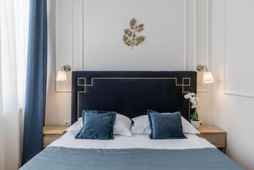 a bedroom with a bed with blue and white pillows at Annex building of Art Hotel in Split